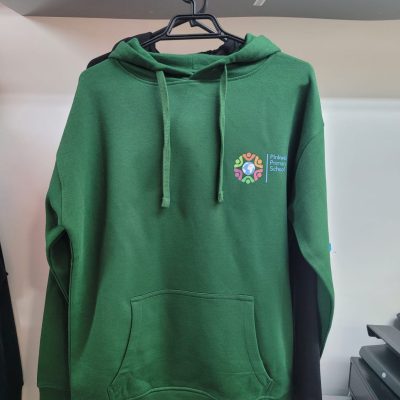 Green hoodie hanging on a hanger with a small multicolored logo printed on the chest.